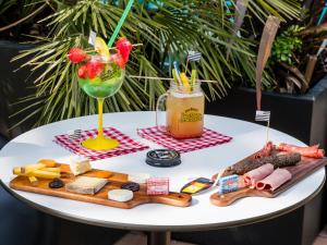- une table avec un plateau de fromage et une boisson dans l'établissement Brit Hotel Ker Lann Aeroport, à Bruz