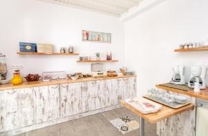 a kitchen with white walls and wooden counters at Porto Bello Tinos in Agios Ioannis