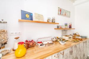 a kitchen counter with food on a wooden counter top at Porto Bello Tinos in Agios Ioannis