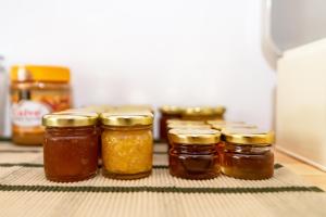 a group of jars of honey sitting in a refrigerator at Porto Bello Tinos in Agios Ioannis