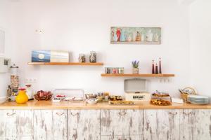 a kitchen with a wooden counter with food on it at Porto Bello Tinos in Agios Ioannis