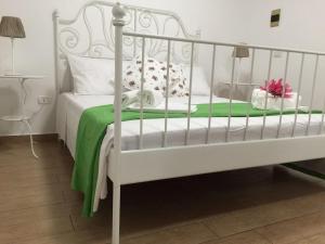 una camera con un letto bianco e una coperta verde di Casa Vacanza Vivaldi Siracusa a Siracusa