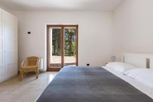 a white bedroom with a large bed and a window at Villa Emary by Perle di Puglia in San Vito dei Normanni