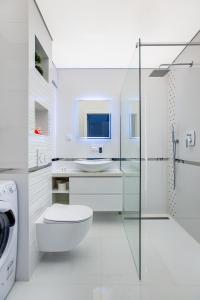 Un baño blanco con inodoro y lavabo. en Apartamenty Bristol, Ul Piotra Ściegiennego 3 mieszkania 54, en Kielce