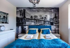 1 dormitorio con 1 cama y una pintura de la ciudad en Apartamenty Bristol, Ul Piotra Ściegiennego 3 mieszkania 54, en Kielce