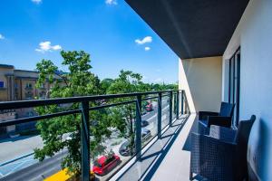 balcón con sillas y vistas a la calle en Apartamenty Bristol, Ul Piotra Ściegiennego 3 mieszkania 54, en Kielce 1 foto más