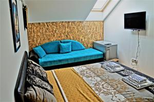 a bedroom with a blue couch and a bed at Central Apartment in Nikšić