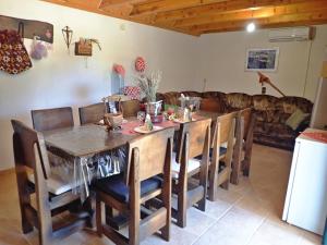 a dining room with a wooden table and chairs at Holiday Home Jukići in Seline