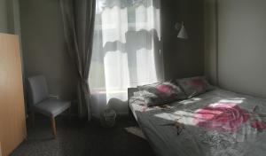 1 dormitorio con 1 cama, 1 silla y 1 ventana en Savi Accommodation, en Valgeranna