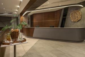 ダル・エス・サラームにあるCrowne Plaza - Dar Es Salaam by IHGのテーブルの上に植物が置かれた受付デスクのあるロビー +37枚の写真