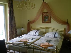 1 dormitorio con 1 cama con lámpara de araña en Am Rasthof Dresdner Tor, en Wilsdruff