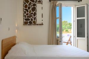 A bed or beds in a room at Filoxenia Apartments