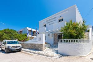 a car parked in front of a white building at Filoxenia Apartments in Adamantas