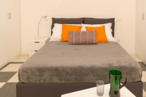 um quarto com uma cama grande e almofadas laranja em Virgiliano Apartment em Roma