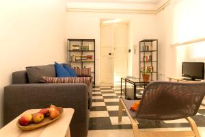 uma sala de estar com um sofá e uma tigela de maçãs numa mesa em Virgiliano Apartment em Roma