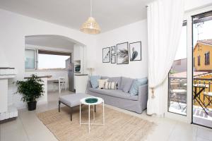 Sala de estar blanca con sofá y mesa en Villa Elisabetta Apartments, en Pula