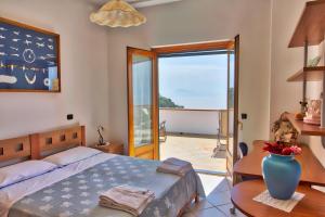 a bedroom with a bed and a large glass door at "CASALENA" Villa a Furore Amalfi coast con grande terrazzo e vista sul MARE in Furore
