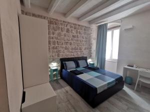 a bedroom with a bed and a brick wall at San Pietro al Borgo in Molfetta