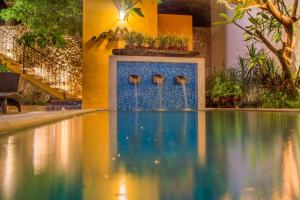 a swimming pool with a fountain in a building at Hotel Boutique Casa Flor de Mayo in Mérida