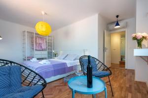um quarto com uma cama, 2 cadeiras e uma mesa em Apartments Simović Old Town em Dubrovnik