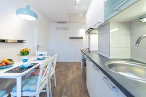 uma cozinha com um lavatório e uma mesa com cadeiras em Apartments Simović Old Town em Dubrovnik