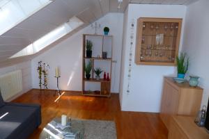 uma sala de estar com um sofá e uma prateleira com copos de vinho em Apartment with a view - Daheim am Wasserturm em Wörth am Rhein