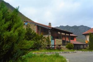 una casa con una montaña en el fondo en Apartamentos Torre Villar, en Villar de Vildas