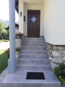 a front door of a house with stairs and a door at Apartment Mlakar in Bohinj