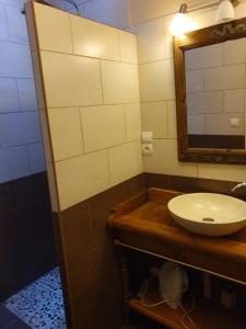 La salle de bains est pourvue d'un lavabo et d'un miroir. dans l'établissement Domaine De Marlas - Gîte de Charme, à Rieucros