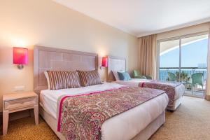 a hotel room with two beds and a balcony at Orange County Belek in Belek