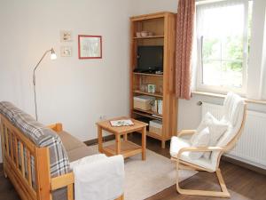 a living room with a couch and a table at Ferienwohnung Die Fuchsmühle in Niedermeiser