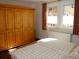 1 dormitorio con 1 cama y algunos armarios de madera en Ferienwohnung Die Fuchsmühle, en Niedermeiser