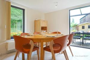 uma sala de jantar com uma mesa de madeira e cadeiras em Gîte les gadlis em Aywaille