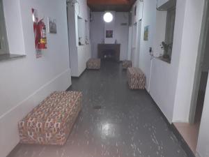 un pasillo con sillas y una chimenea en un edificio en Hostal Amalaya en Salta