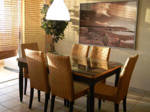 comedor con mesa de cristal y sillas en Apartment Continental Beach Resort, en Río Grande