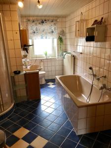 y baño con bañera, aseo y lavamanos. en Ferienwohnung Frankenwald, en Naila
