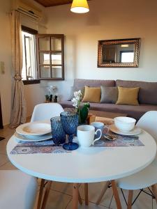 sala de estar con mesa blanca y sillas en Emmanouil airport beach apartment, en Karteros