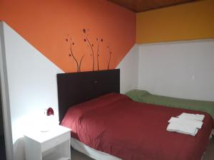 1 dormitorio con cama roja y pared roja en Hostal Amalaya en Salta