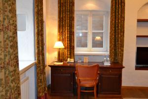 a desk in a room with a window and a chair at Daugirdas Old City Hotel in Kaunas