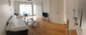a living room with a white couch and a television at ARCACHON appartement T2 51M2 et parking privatif en sous sol in Arcachon