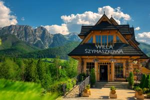 a large building with a clock on the side of it at Willa Szymaszkowa in Zakopane