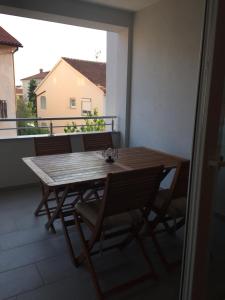 drewniany stół i krzesła na balkonie w obiekcie Apartman Medulin w Medulinie +15 zdjęć