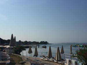 plaża z leżakami, parasolami i wodą w obiekcie Apartman Medulin w Medulinie