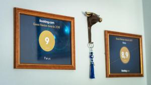 two picture frames hanging on a wall with a key at Parus Boutique Hotel in Jūrmala