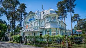 a blue and white house with a fence at Parus Boutique Hotel in Jūrmala