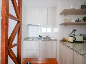 a kitchen with white cabinets and a sink at Fanqueiros 196 - Center City Apt in Lisbon