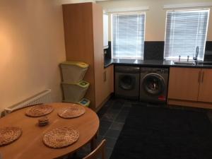 a kitchen with a table and a washing machine at Thurso Self Catering Pet Friendly Holiday Lets in Thurso