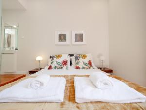 a white bedroom with two white towels on a bed at Fanqueiros 196 - Center City Apt in Lisbon