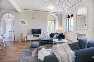 sala de estar con sofás azules y TV en Villa Marchi en Hvar