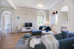 a living room with blue couches and a tv at Villa Marchi in Hvar